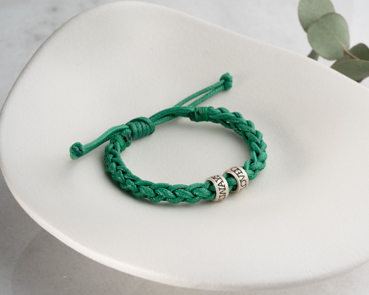 Women's hand-braided bracelet with personalized charms, handmade by Artizian